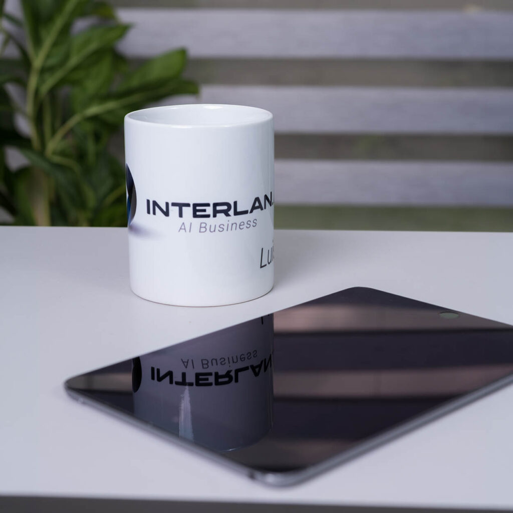 Elementos de identidad visual corporativa con taza personalizada y tablet sobre escritorio de trabajo