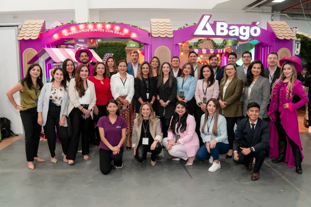 Grupo de profesionales posando en un stand corporativo durante una cumbre de sostenibilidad, en un entorno de feria empresarial con material informativo y branding de la marca.