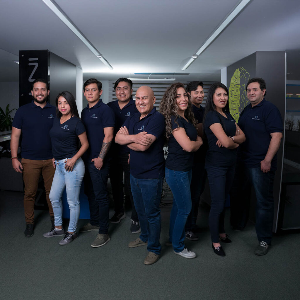 Equipo de colaboradores de empresa tecnológica posando en oficinas corporativas durante sesión fotográfica empresarial