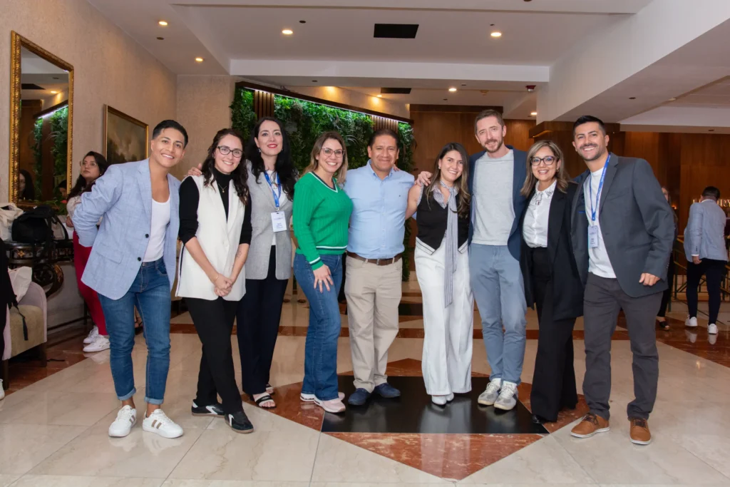 Grupo de asistentes a un congreso de medicina en un auditorio, participando en un evento científico con ambiente profesional y ponencias académicas.