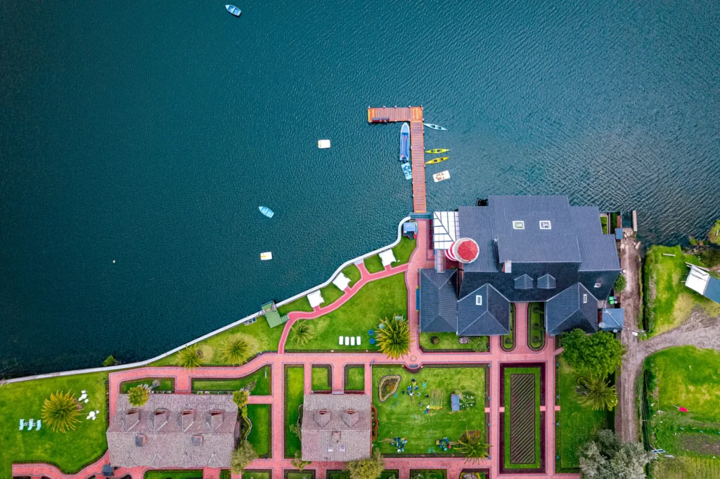 Vista cenital de hotel ubicado junto a un lago capturada con dron para fotografía arquitectónica y turística