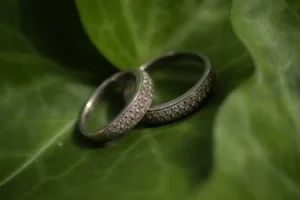 Anillos de boda sobre hojas verdes en una composición fotográfica de detalle