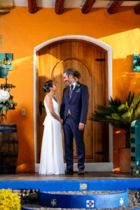 Novios posando en el portal de una casa de campo durante su sesión fotográfica de boda