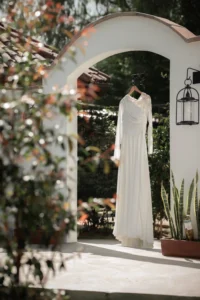 Vestido de novia colgado en el arco de entrada de una finca durante los preparativos de la boda